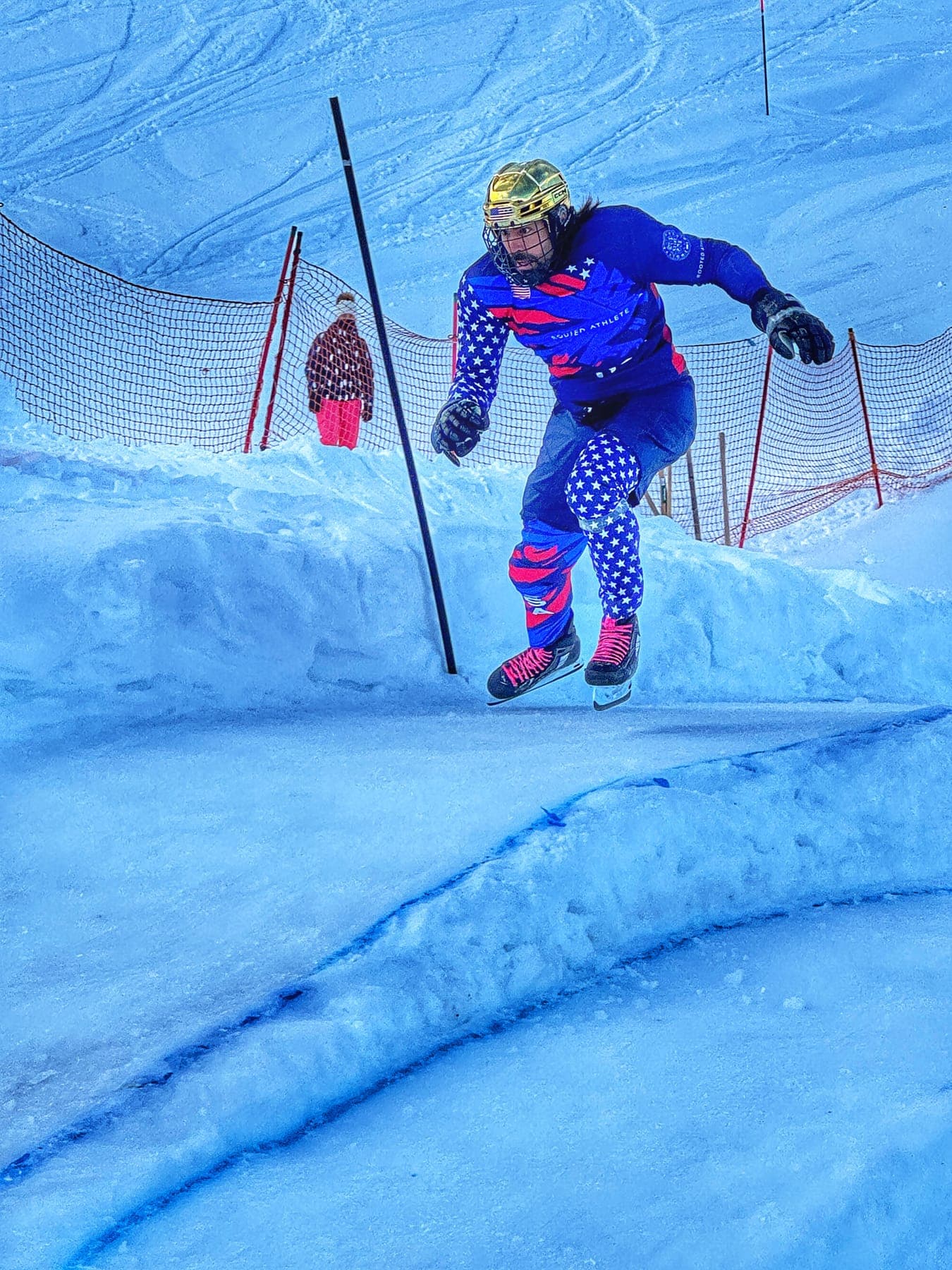 A rider in a stars-and-stripes suit skating down the ice track
