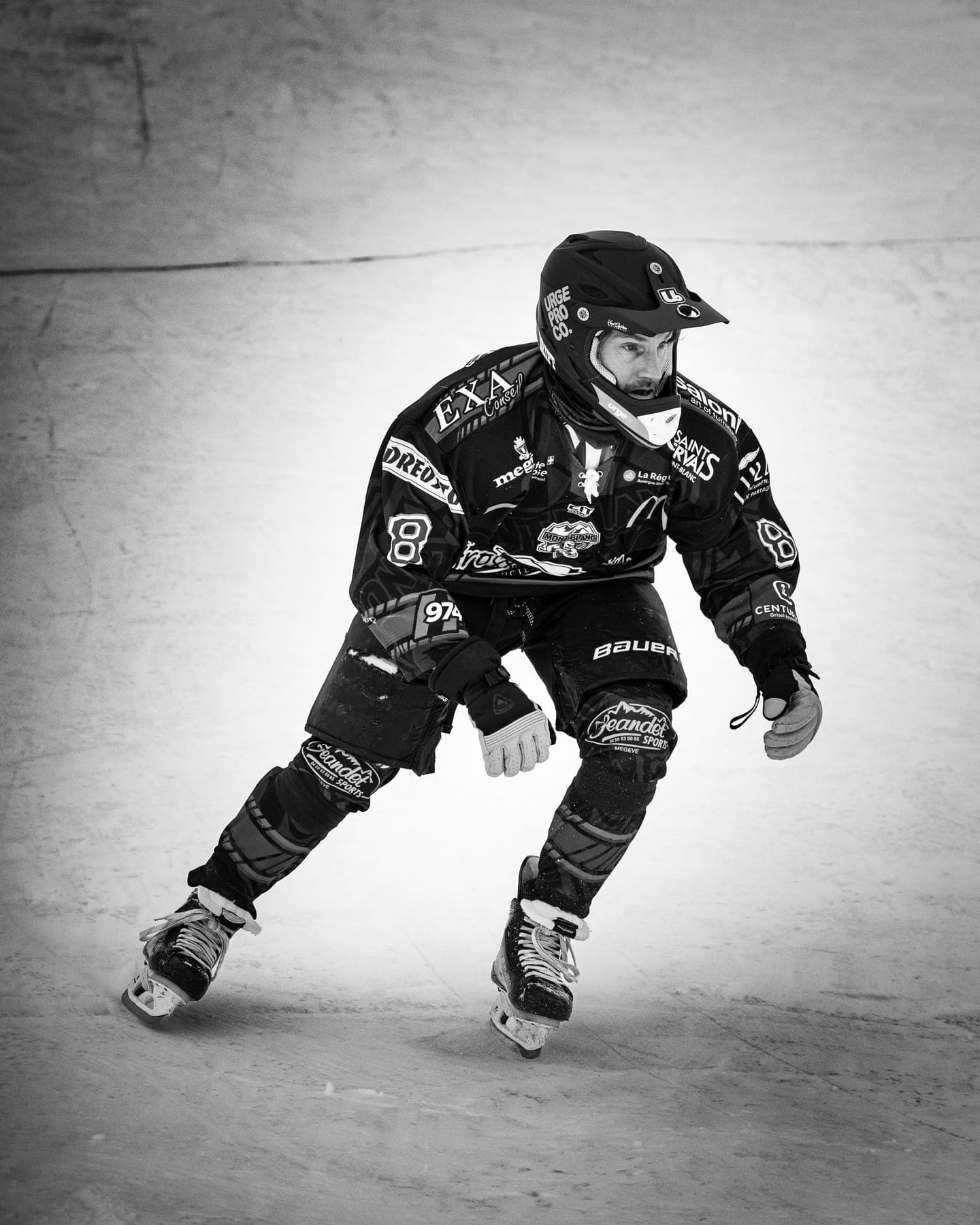 A rider in black race gear skating towards the camera, in black and white