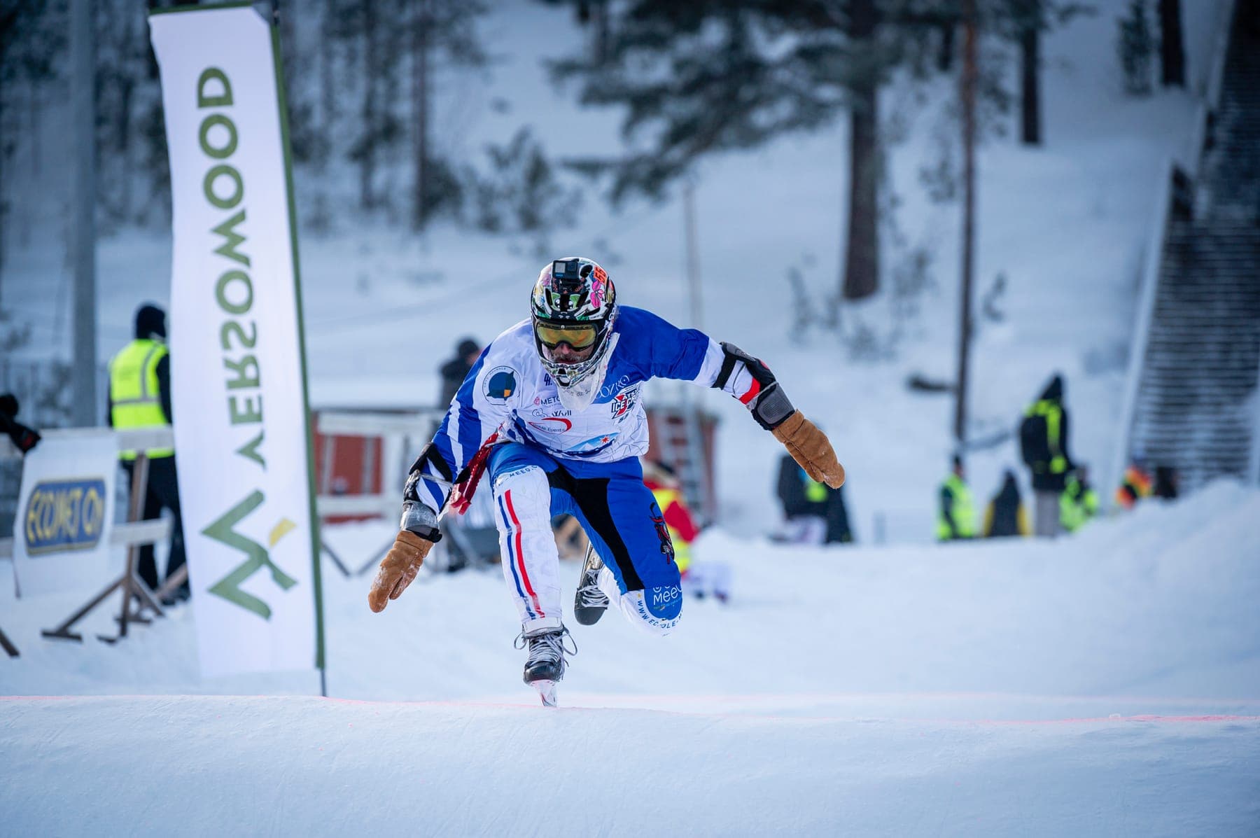 A rider in a French team suit jumping a bump on the track