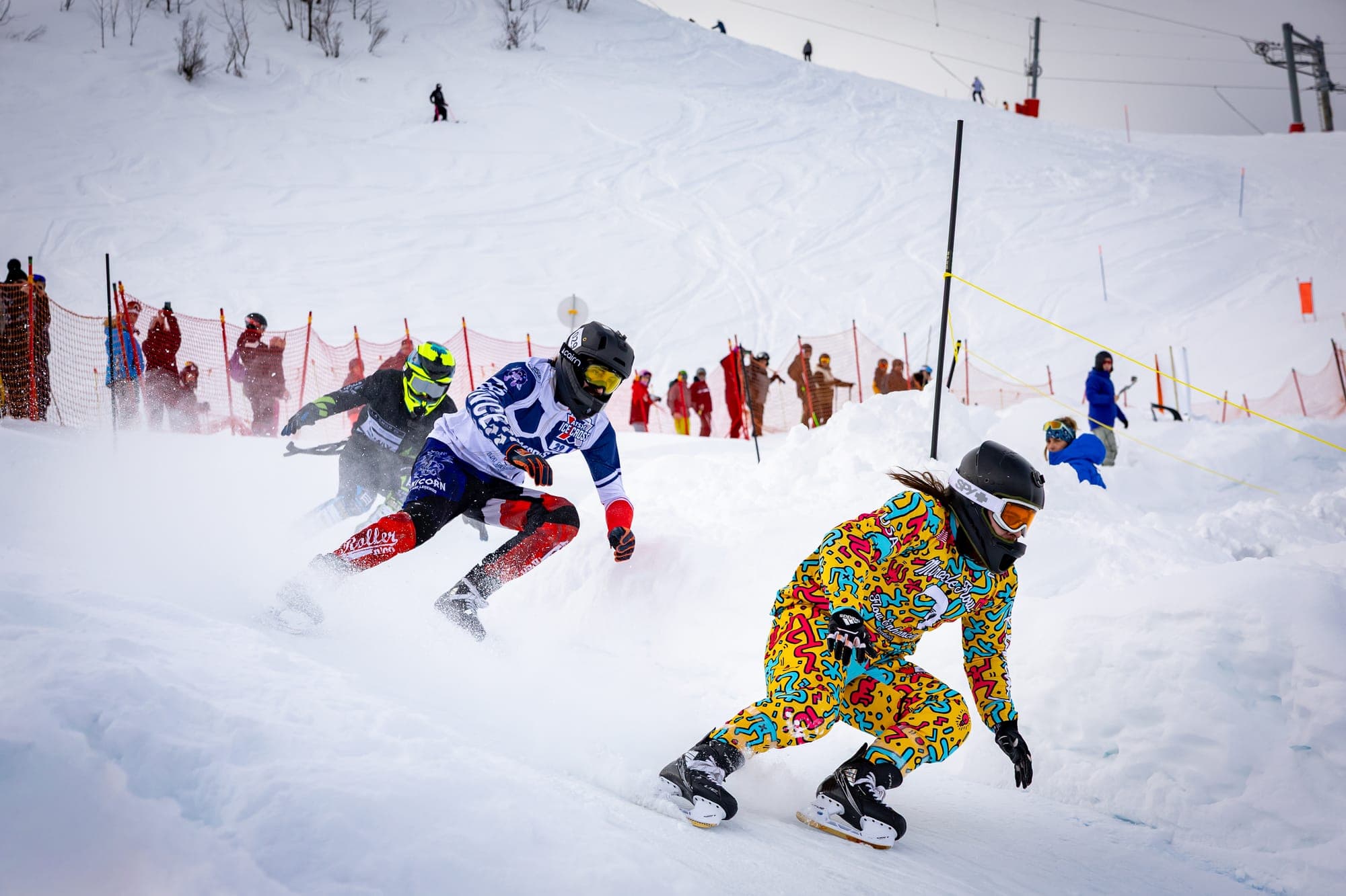 Riders sprinting downhill, one of them in a colourful patterned suit
