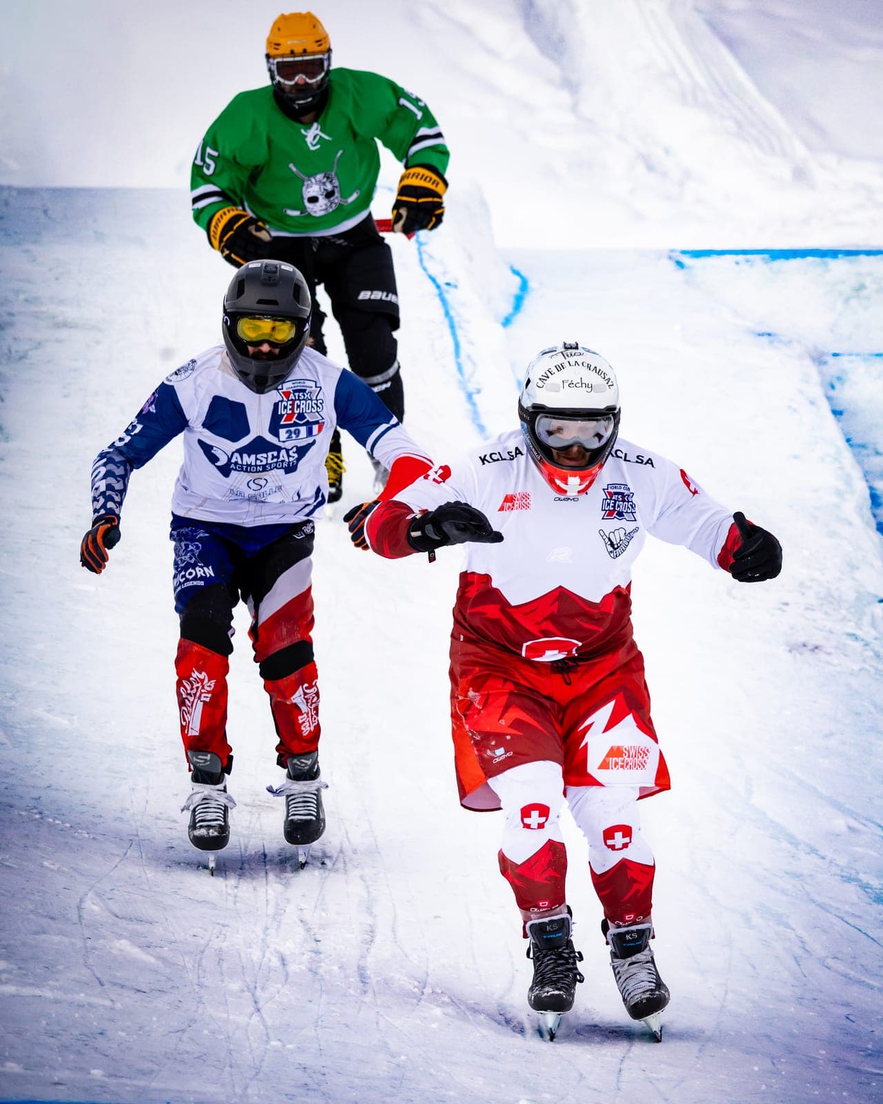 Three riders racing close together down the ice, one in a Swiss team suit